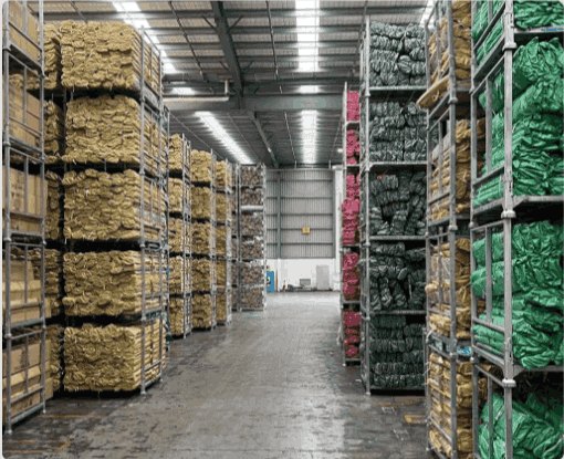 Warehouse aisle with wrapped goods held in stillage cages.